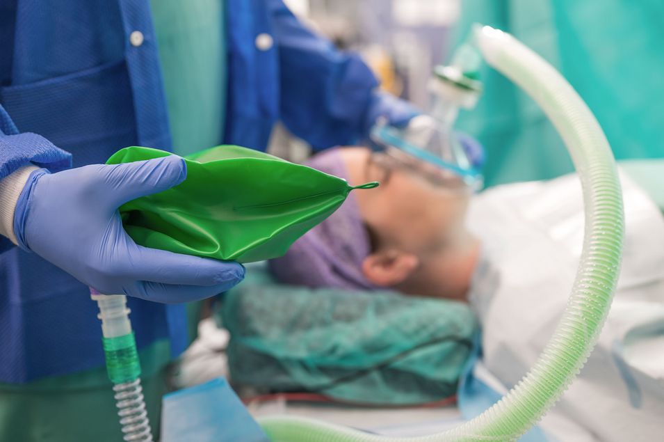 Nahaufnahme einer jungen Patientin, die vor der Operation eine Narkose erhält. Nahaufnahme einer jungen Patientin, die mit geschlossenen Augen im Operationssaal liegt und vor der Operation eine Narkose erhält