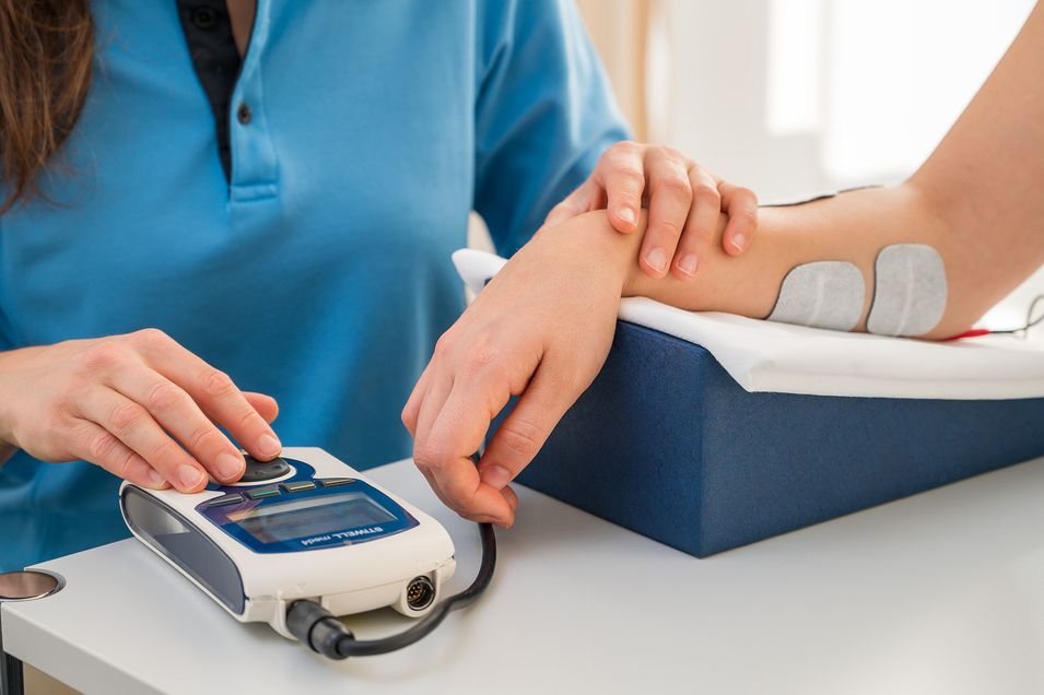 Genau dosierte Reize zur Stärkung der Muskulatur. Hautelektroden sind am Unterarm einer Patientin befestigt und leiten elektrische Impulse an die Armmuskulatur weiter.
